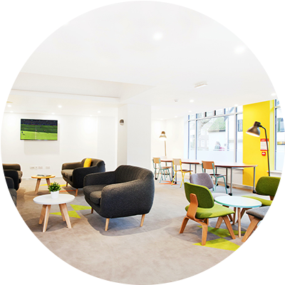 A room furnished with several chairs and tables arranged for seating and gatherings.